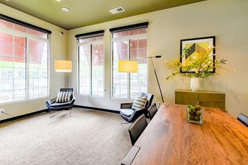 a conference room with a wooden table and chairs and large windows at Riverset Apartments, Memphis, 38103